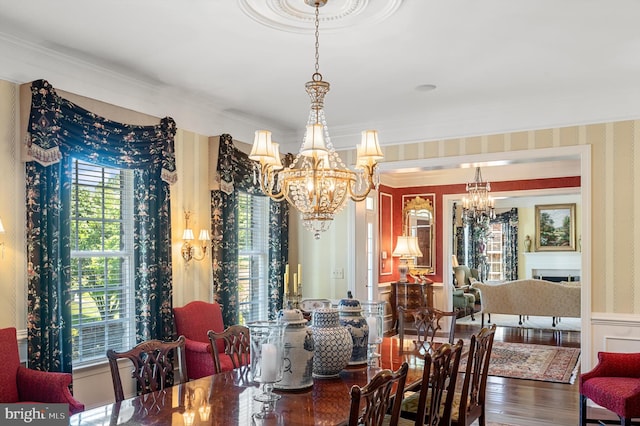 dining space with crown molding, hardwood / wood-style floors, and a notable chandelier