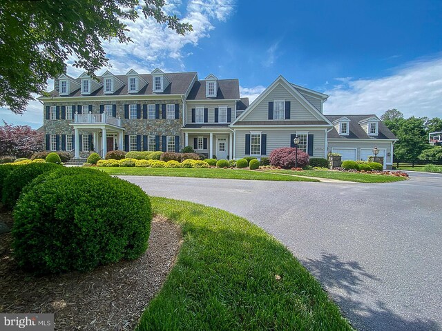 view of front of home with stone siding and a balcony