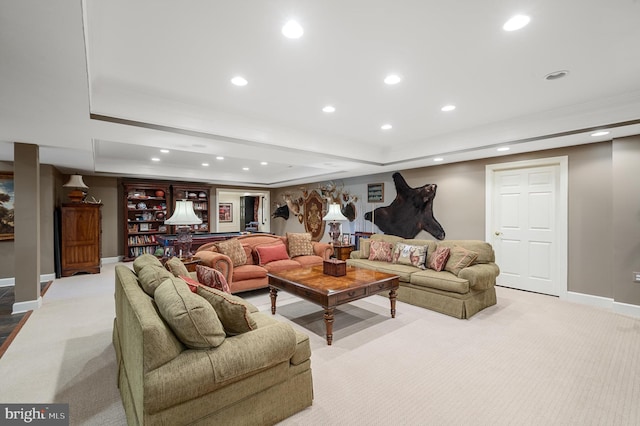 living room featuring a tray ceiling and light colored carpet