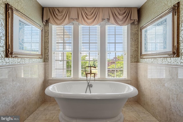 full bathroom featuring wallpapered walls, tile patterned floors, and wainscoting