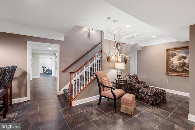 living area with crown molding and dark tile patterned floors