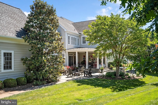 rear view of property featuring a yard and a patio