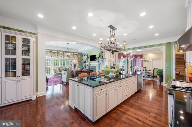 kitchen with decorative light fixtures, a chandelier, a center island, stainless steel appliances, and white cabinets