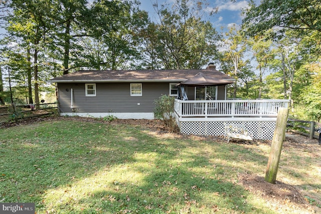 rear view of property with a lawn and a deck