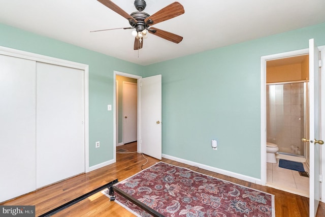 bedroom with ceiling fan, a closet, wood-type flooring, and connected bathroom