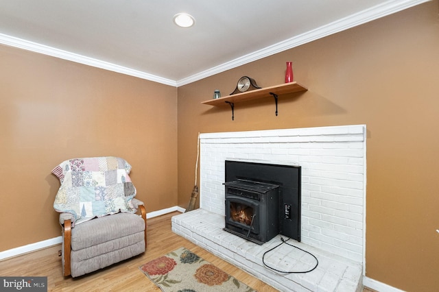 sitting room with crown molding, hardwood / wood-style floors, and a wood stove