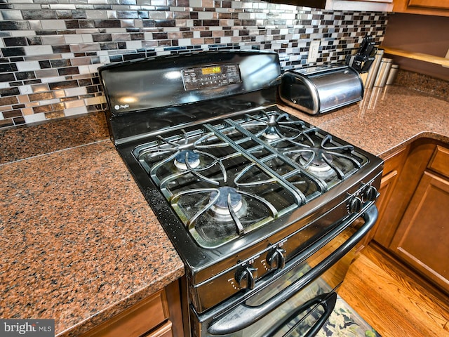 interior details featuring tasteful backsplash and black gas stove