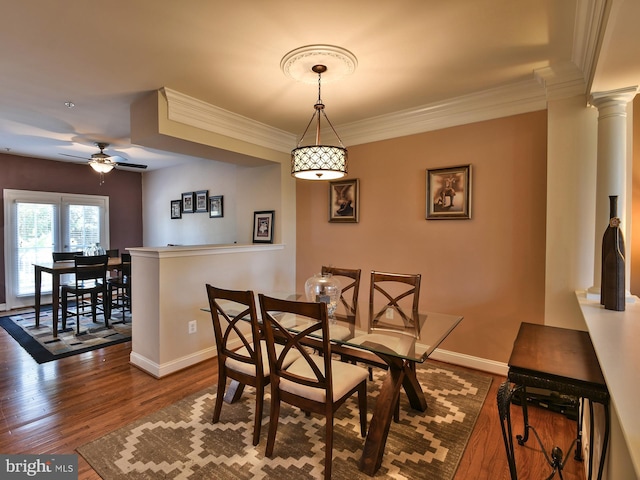 dining area with ornate columns, crown molding, hardwood / wood-style floors, and ceiling fan