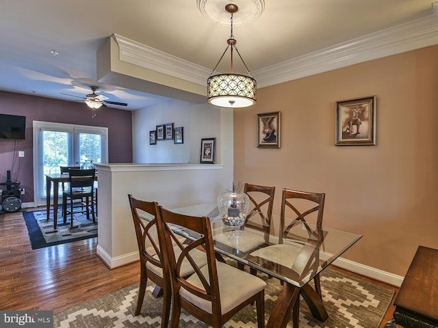 dining area with hardwood / wood-style flooring, crown molding, and ceiling fan