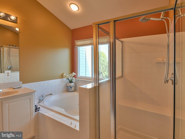 bathroom with lofted ceiling, vanity, and independent shower and bath