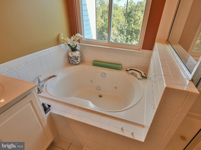 bathroom featuring tiled tub, tile patterned floors, and vanity