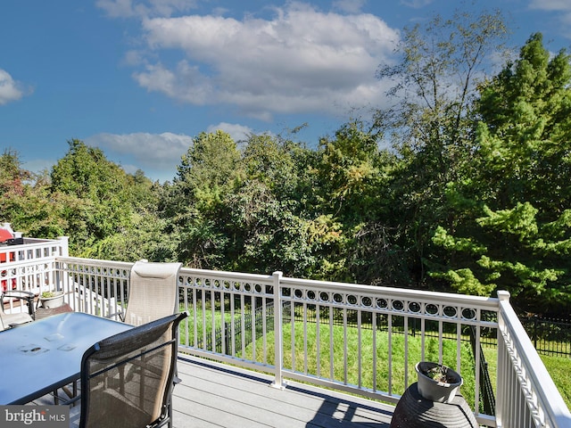 wooden deck featuring a lawn