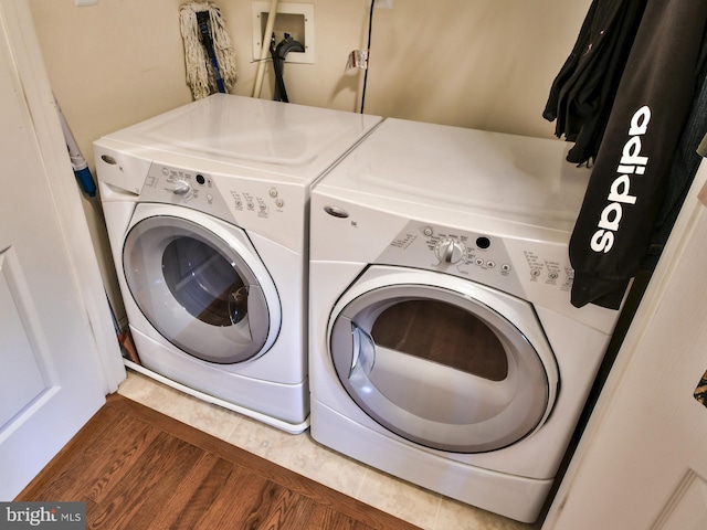 laundry room with dark hardwood / wood-style flooring and washing machine and clothes dryer