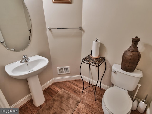 bathroom with hardwood / wood-style flooring, sink, and toilet