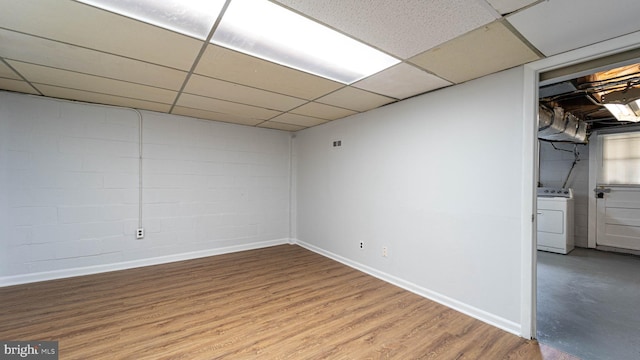 basement featuring a drop ceiling, light hardwood / wood-style flooring, and washer / clothes dryer