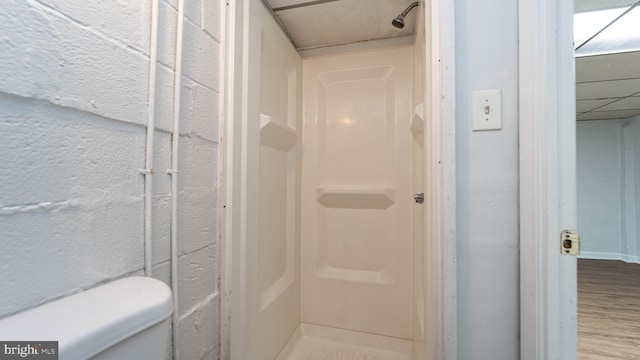 bathroom with toilet, hardwood / wood-style floors, and a shower