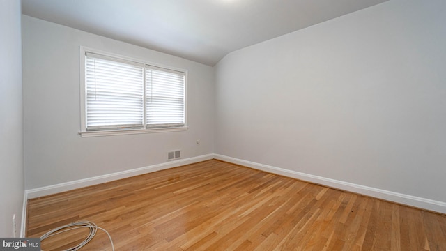 empty room with lofted ceiling and light wood-type flooring