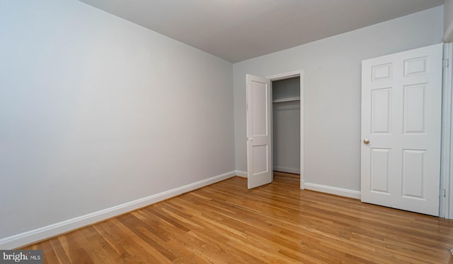 unfurnished bedroom with a closet and light hardwood / wood-style floors