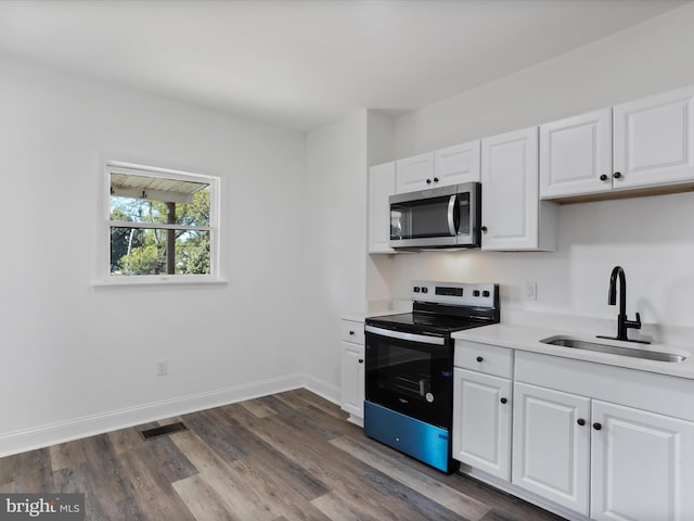 kitchen with dark wood-type flooring, white cabinetry, stainless steel appliances, and sink