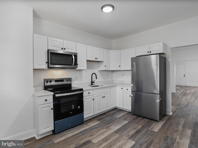 kitchen with light countertops, white cabinetry, stainless steel appliances, and a sink
