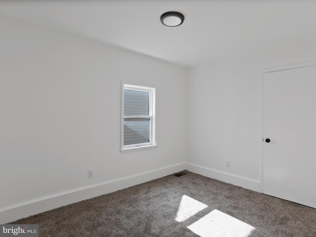 unfurnished room with visible vents, baseboards, and carpet
