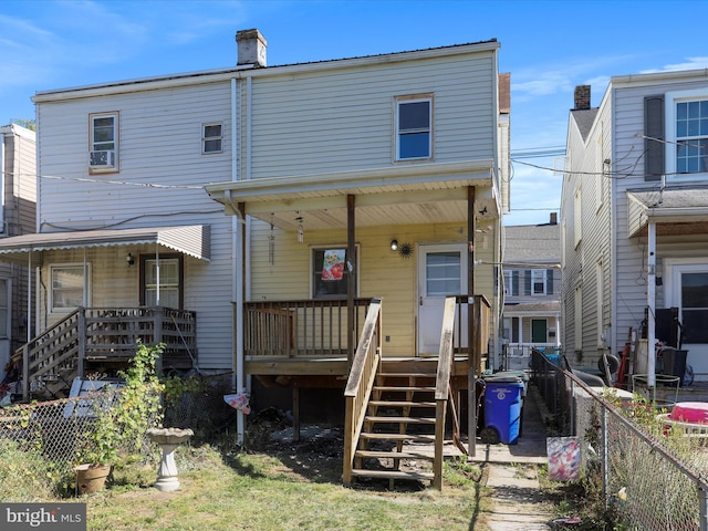 back of property with covered porch, fence private yard, and a chimney