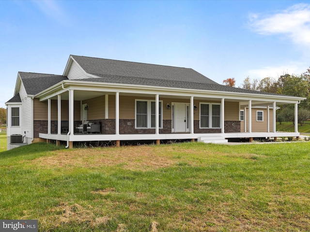 farmhouse with a front lawn, central air condition unit, covered porch, and roof with shingles