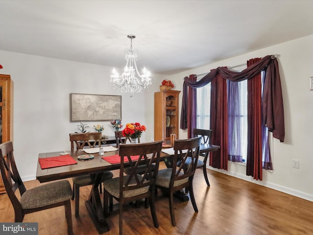 dining space featuring hardwood / wood-style flooring and a chandelier