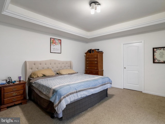 bedroom with carpet flooring, a raised ceiling, and baseboards