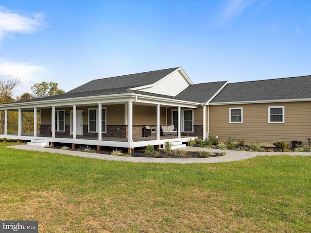 view of front of house with roof with shingles, covered porch, and a front lawn