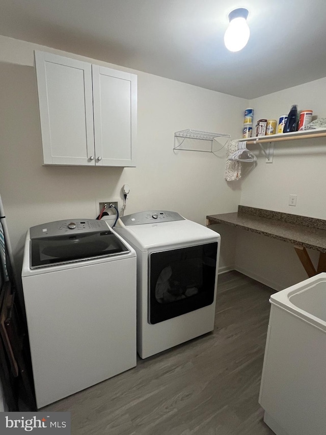 laundry room featuring cabinet space, independent washer and dryer, and wood finished floors