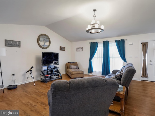 living area with lofted ceiling, wood finished floors, a chandelier, and baseboards