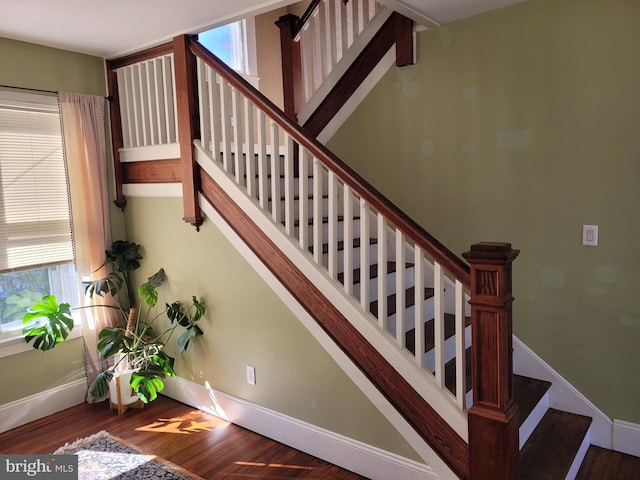 staircase featuring hardwood / wood-style floors and a healthy amount of sunlight