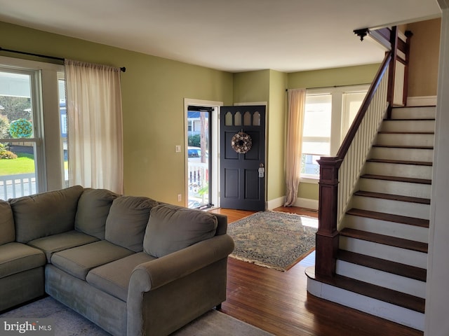 living room with dark wood-type flooring and plenty of natural light