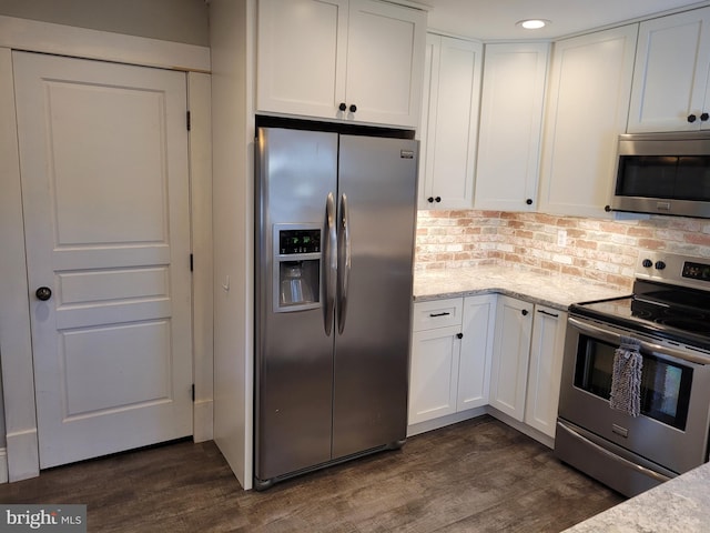 kitchen with white cabinets, tasteful backsplash, dark hardwood / wood-style flooring, appliances with stainless steel finishes, and light stone countertops