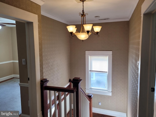 staircase featuring crown molding and ceiling fan with notable chandelier