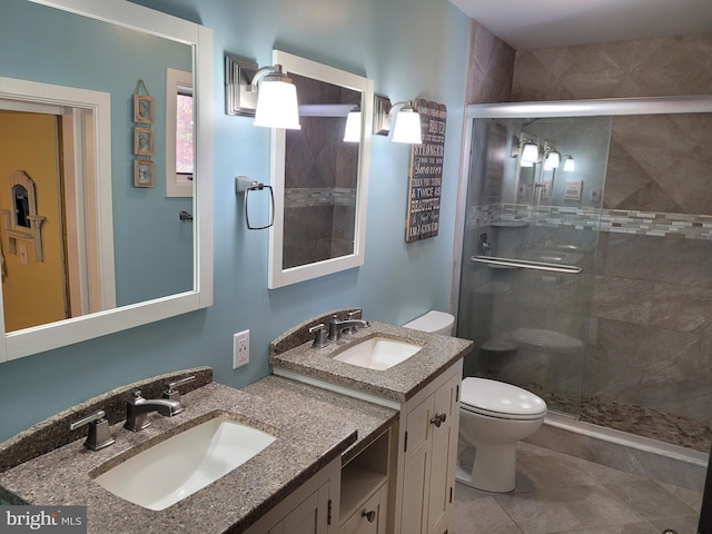 bathroom with vanity, walk in shower, toilet, and tile patterned floors