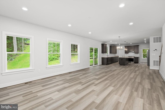 unfurnished living room with a healthy amount of sunlight and light hardwood / wood-style floors