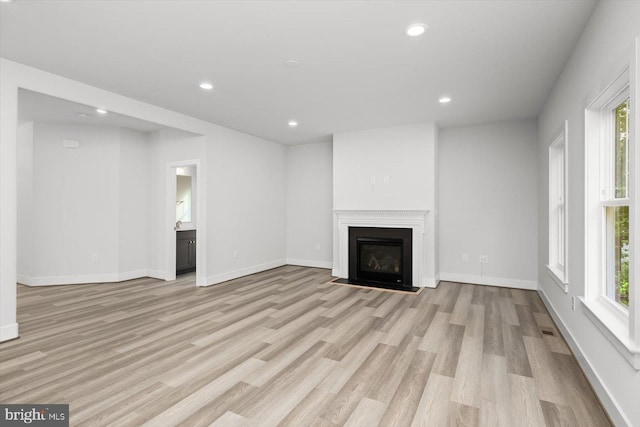 unfurnished living room featuring light hardwood / wood-style flooring and a healthy amount of sunlight