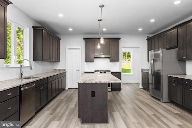 kitchen with plenty of natural light, appliances with stainless steel finishes, sink, and a center island