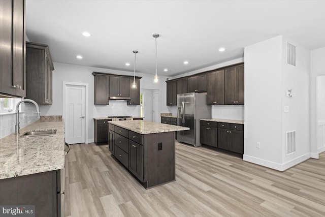 kitchen featuring a kitchen island, light wood-type flooring, sink, dark brown cabinets, and stainless steel fridge with ice dispenser