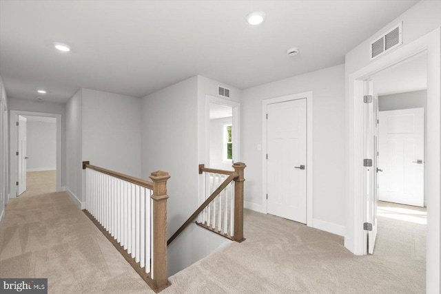 hallway with light colored carpet