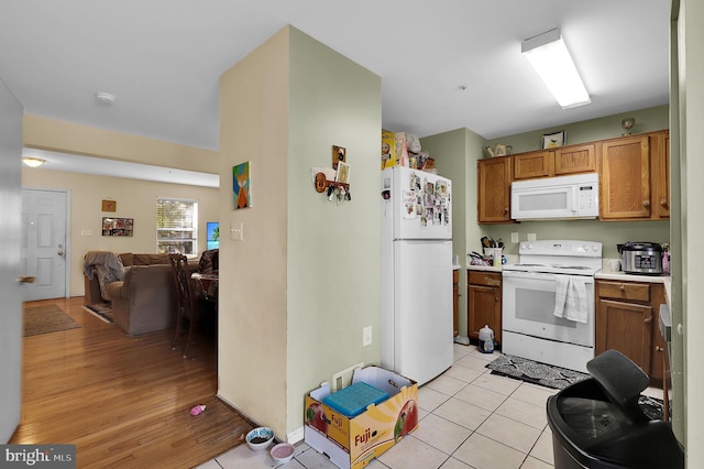 kitchen with light wood-type flooring and white appliances