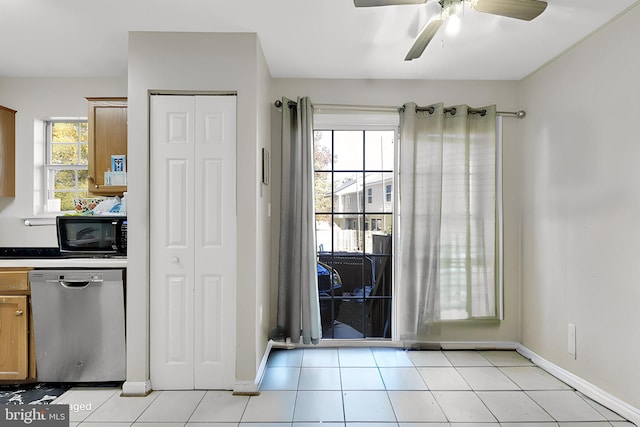 kitchen with stainless steel dishwasher, light tile patterned floors, and plenty of natural light