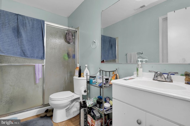 bathroom with vanity, toilet, and an enclosed shower