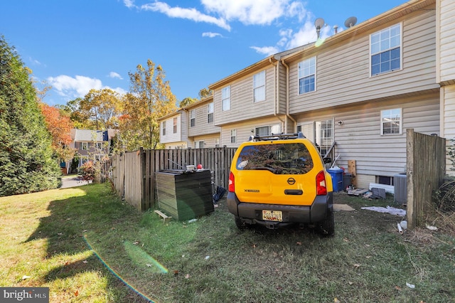 rear view of property with a lawn and central AC unit