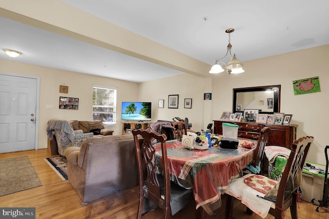 dining space with hardwood / wood-style flooring and an inviting chandelier