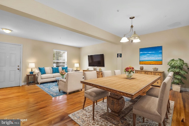 dining area featuring light hardwood / wood-style flooring and a notable chandelier