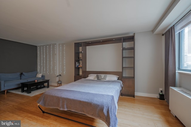 bedroom featuring light hardwood / wood-style floors and radiator