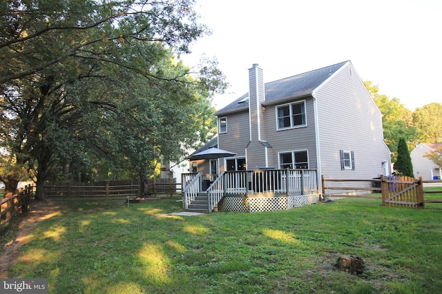 rear view of property featuring a yard and a deck